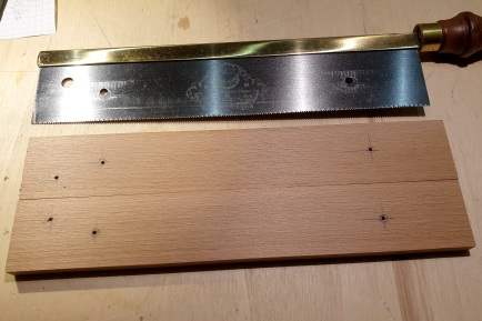 Fret slotting saw on workbench, together with two 10x40mm pieces beech cut to the length of the saw blade, positions for wholes marked, pilot holes drilled